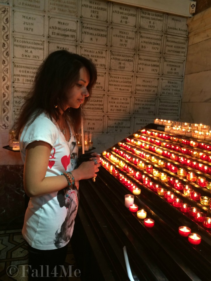 Woman praying and lighting a candle in church
