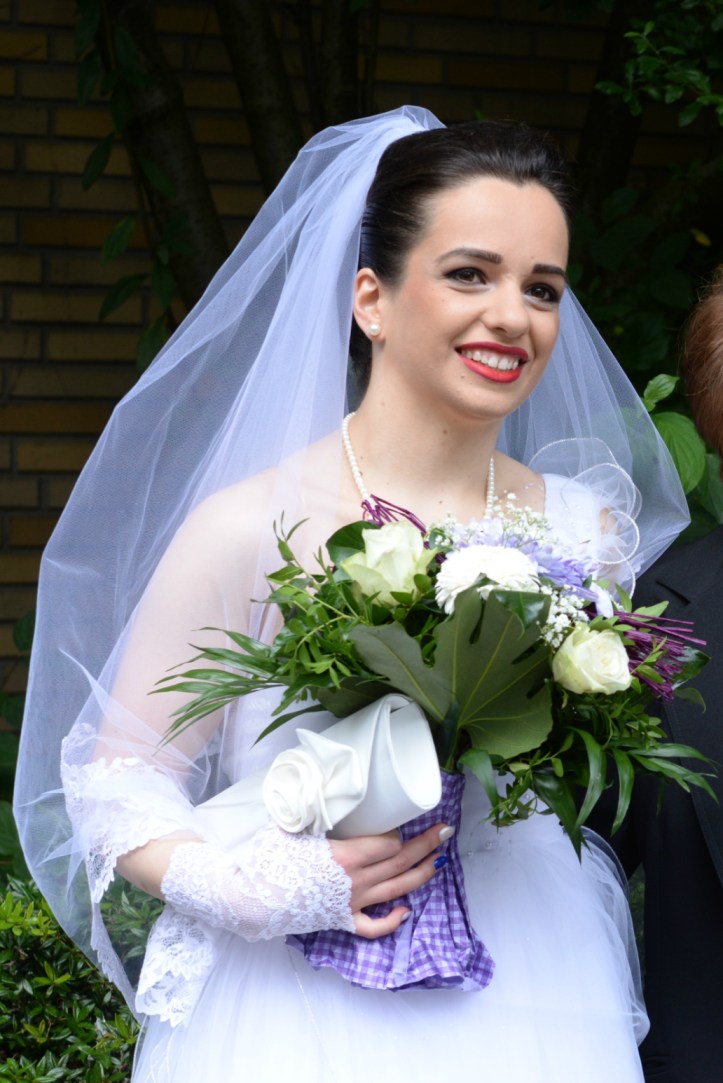 The bride holding her bouquet and bag