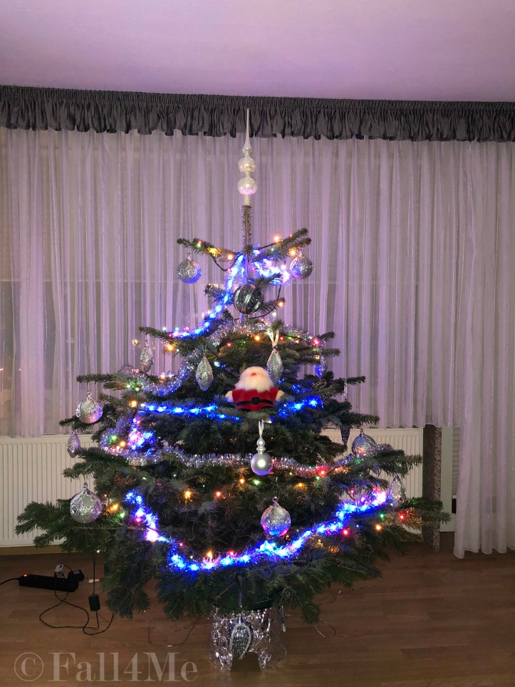 A Christmas tree decorated in white and silver