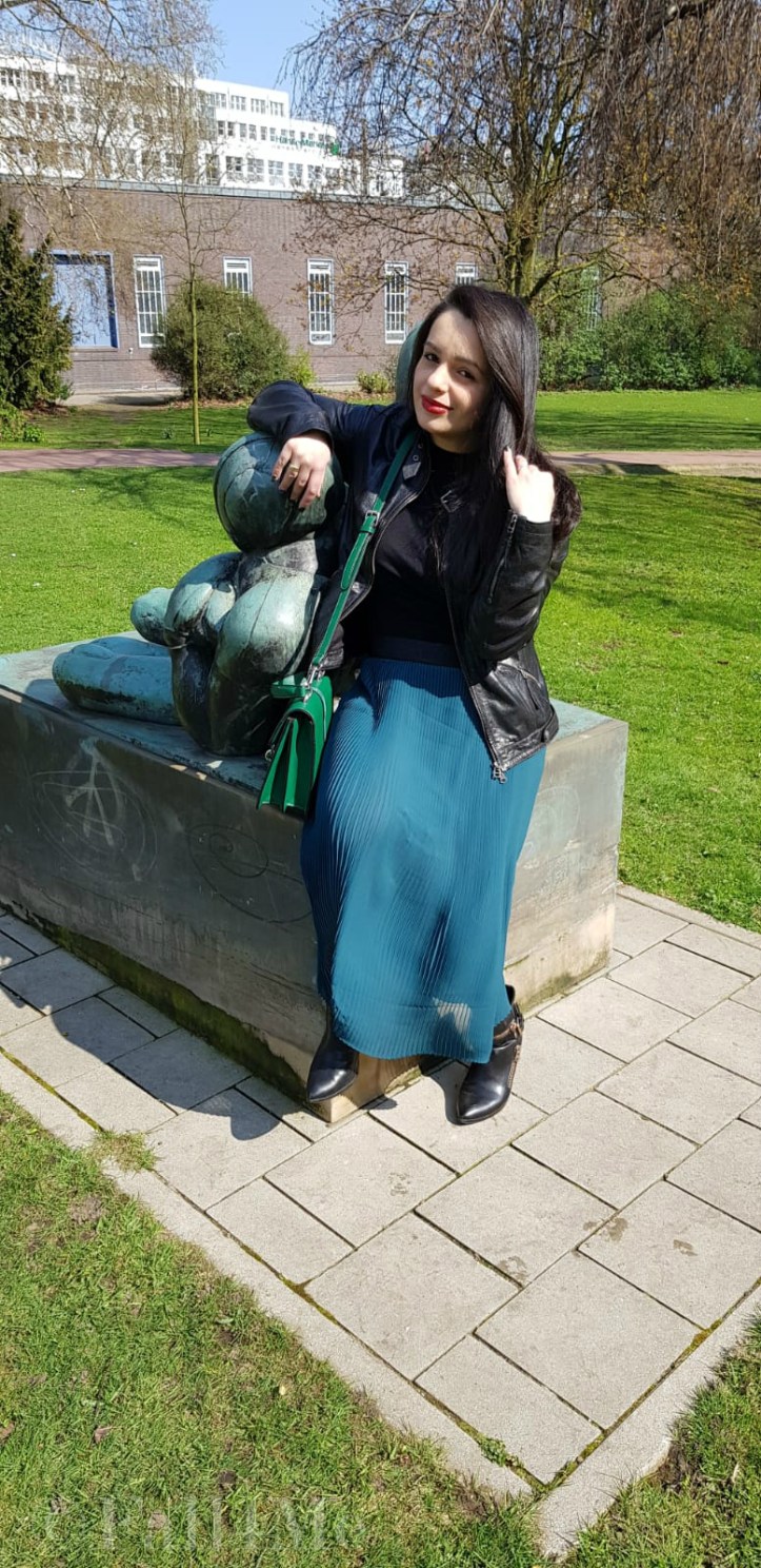 Spring-style in black and green: a leather jacket and a skirt
