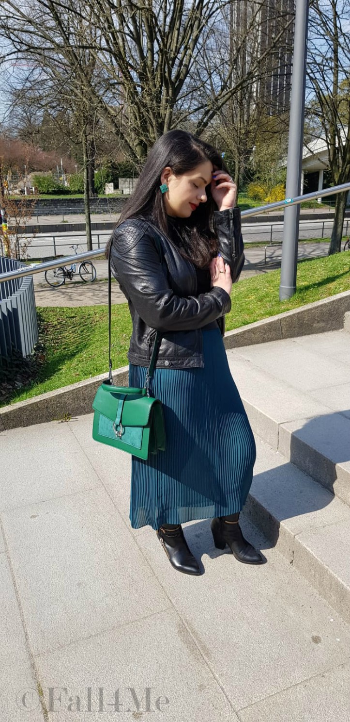 Spring-style in black and green: a leather jacket and a skirt