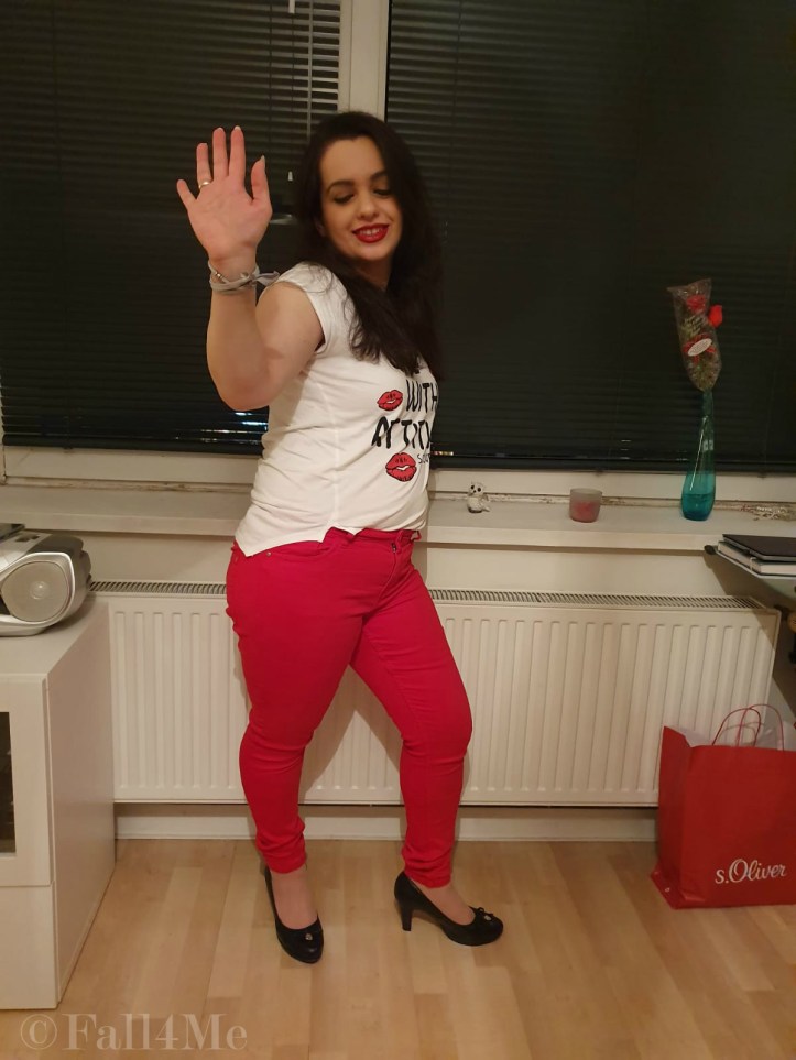 A white shirt combined with red jeans and black pumps