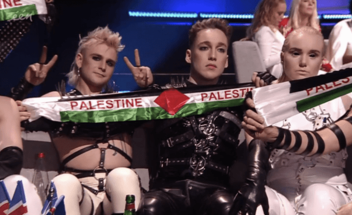 The members of Hatari raising flags and banners of Palestine in the Green Room during the Grand Final of Eurovision 2019