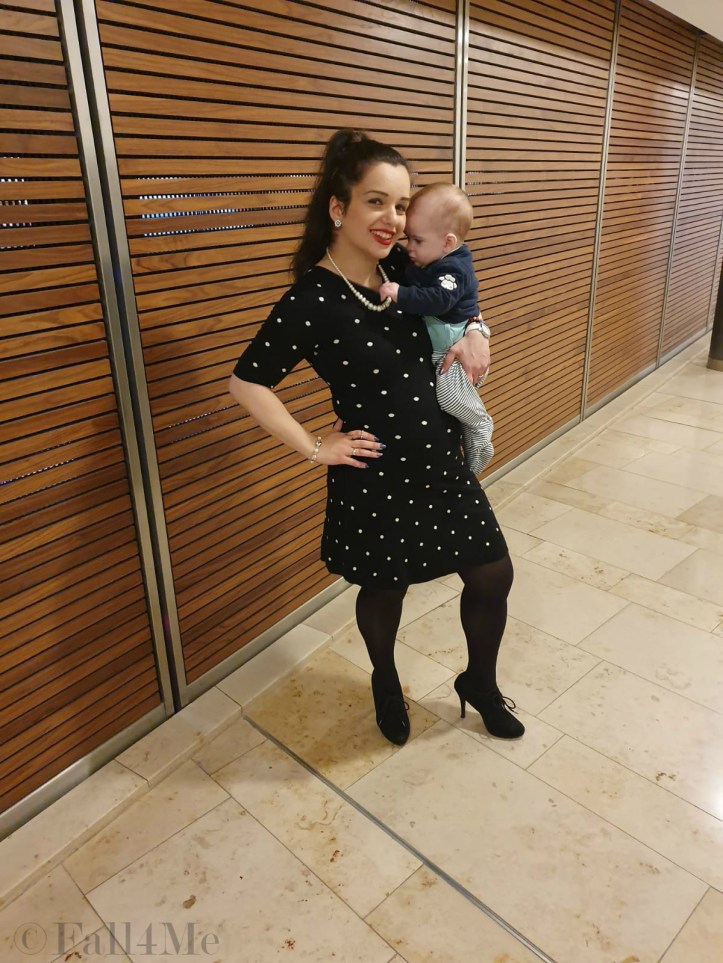 A black dress with white polka-dots combined with pearls and red lips.