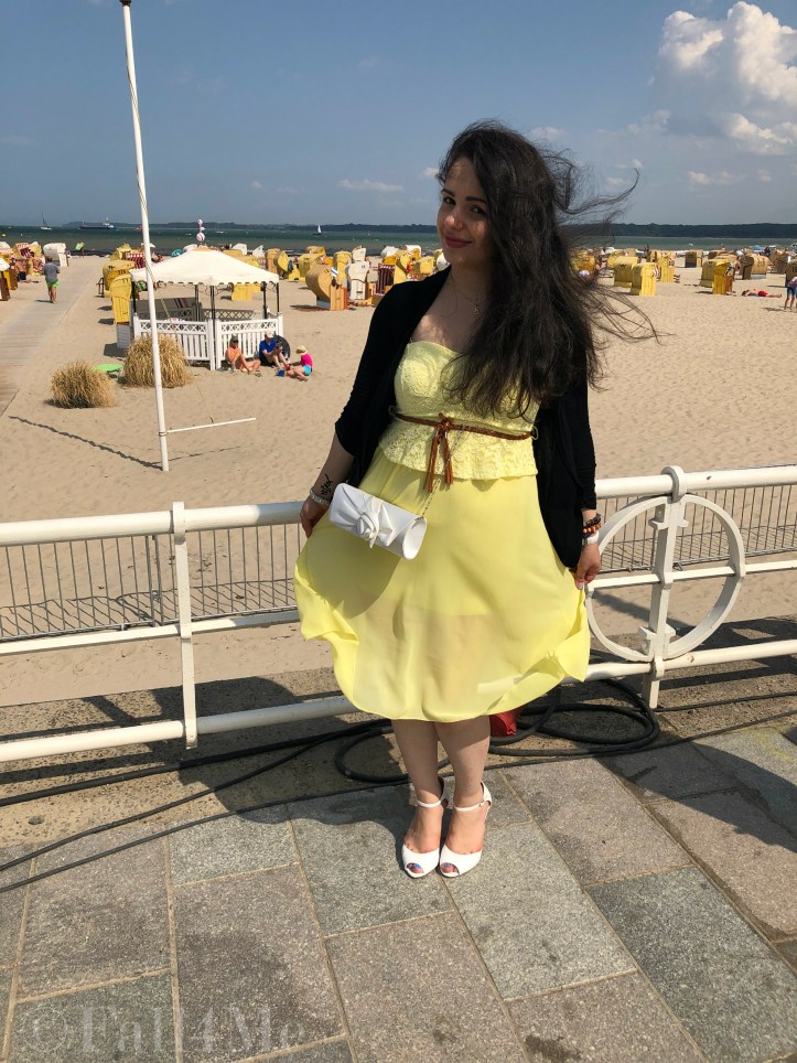 A dress in lemon yellow elegantly combined with black and white and green accents