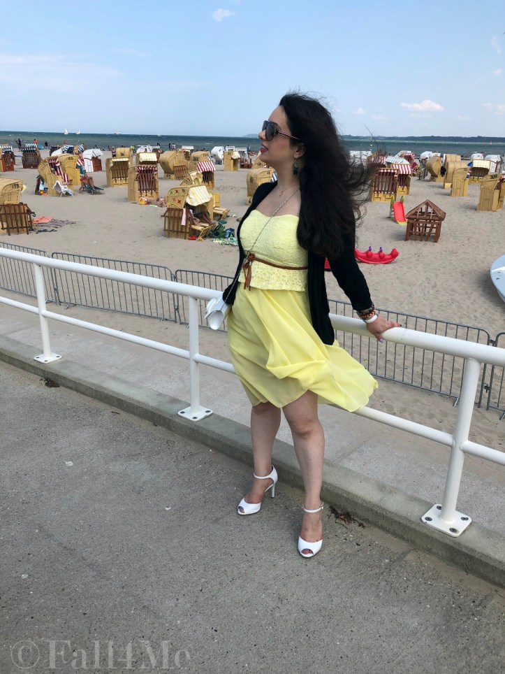 A dress in lemon yellow elegantly combined with black and white and green accents