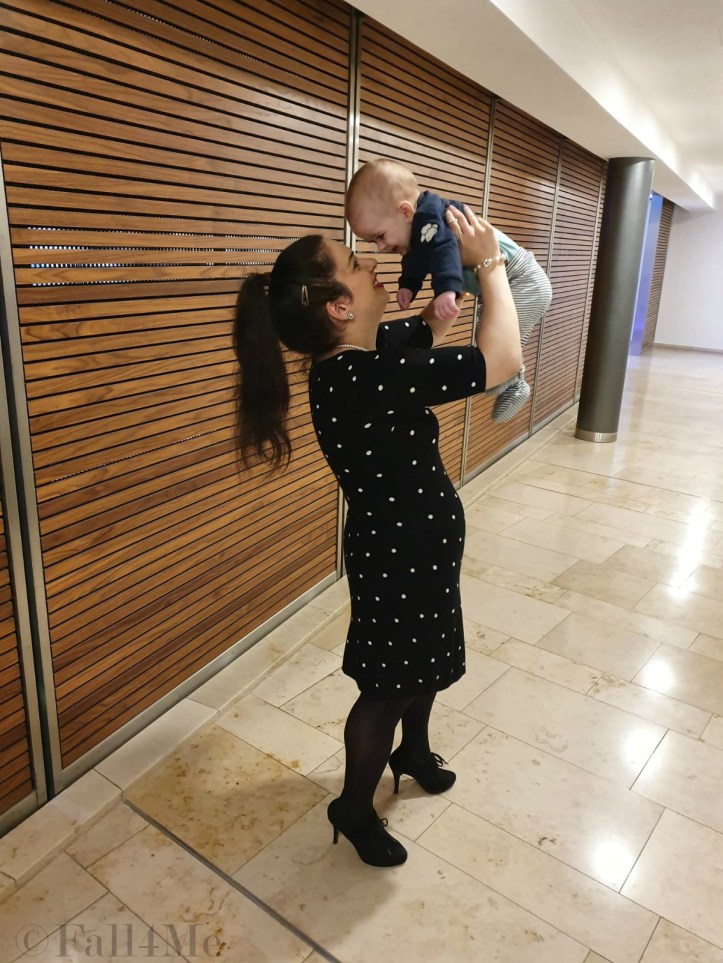 A black dress with white polka-dots combined with pearls and red lips.