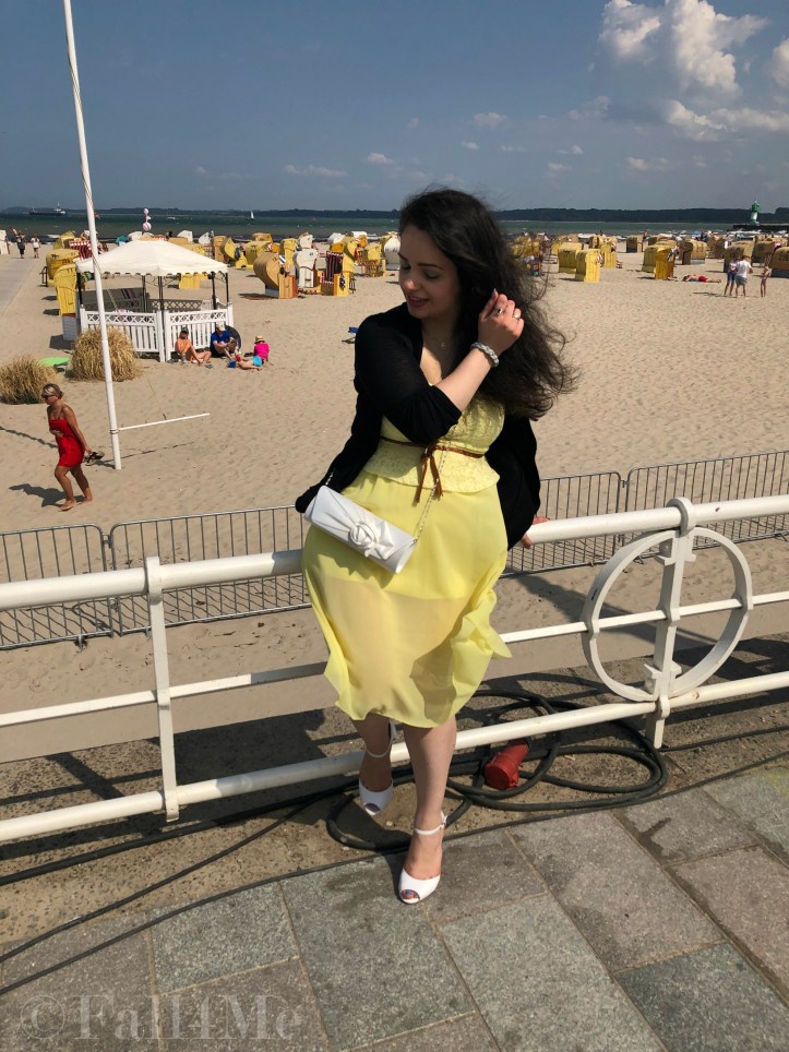 A dress in lemon yellow elegantly combined with black and white and green accents