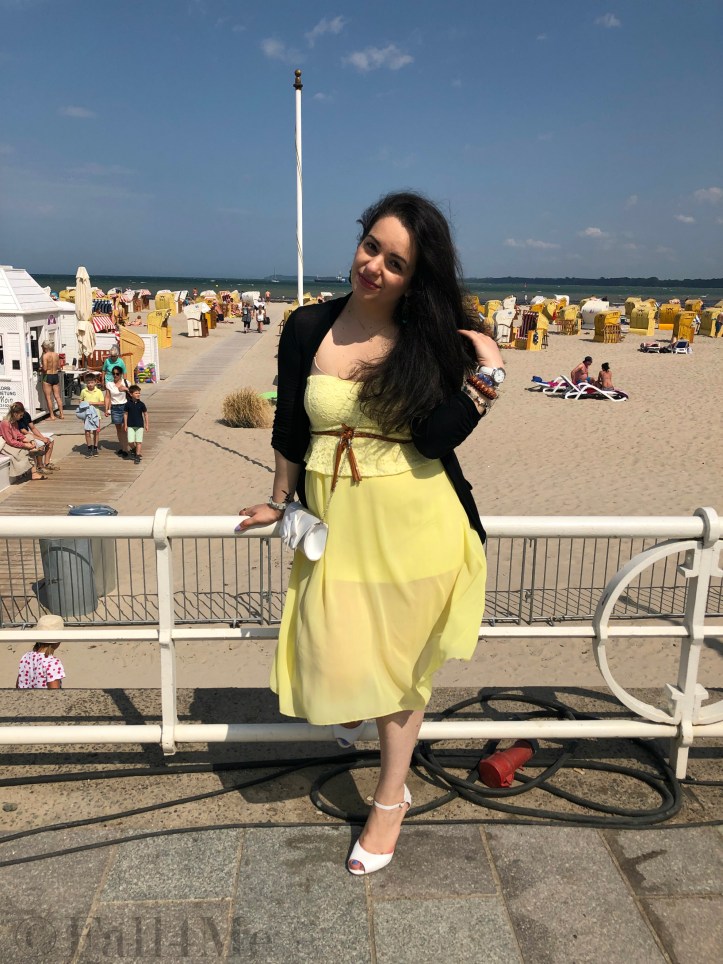 A dress in lemon yellow elegantly combined with black and white and green accents