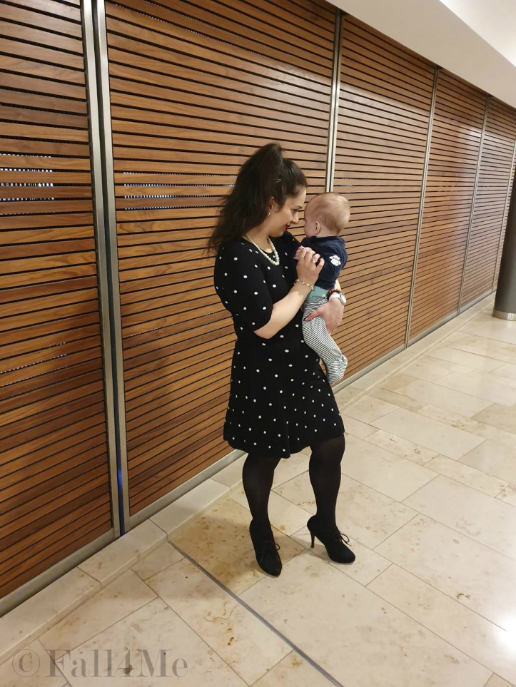 A black dress with white polka-dots combined with pearls and red lips.