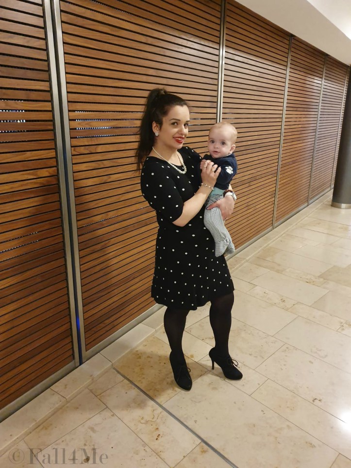 A black dress with white polka-dots combined with pearls and red lips.