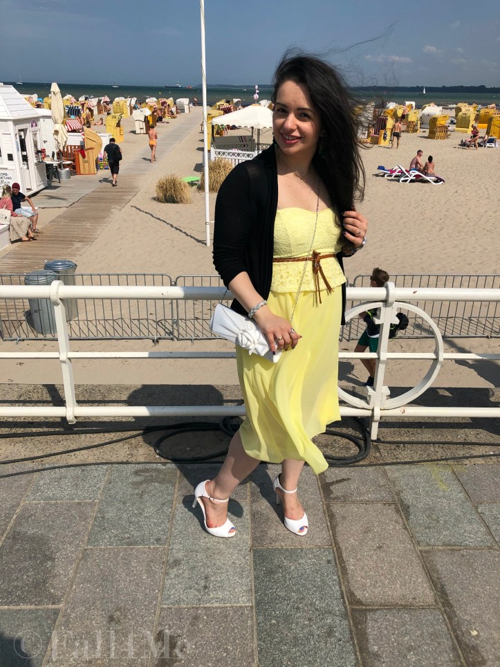A dress in lemon yellow elegantly combined with black and white and green accents