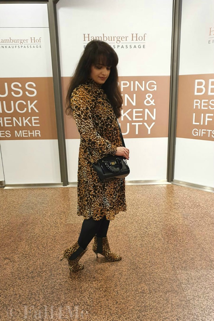 A leo-print dress styled with corresponding ankle boots and black accessories.