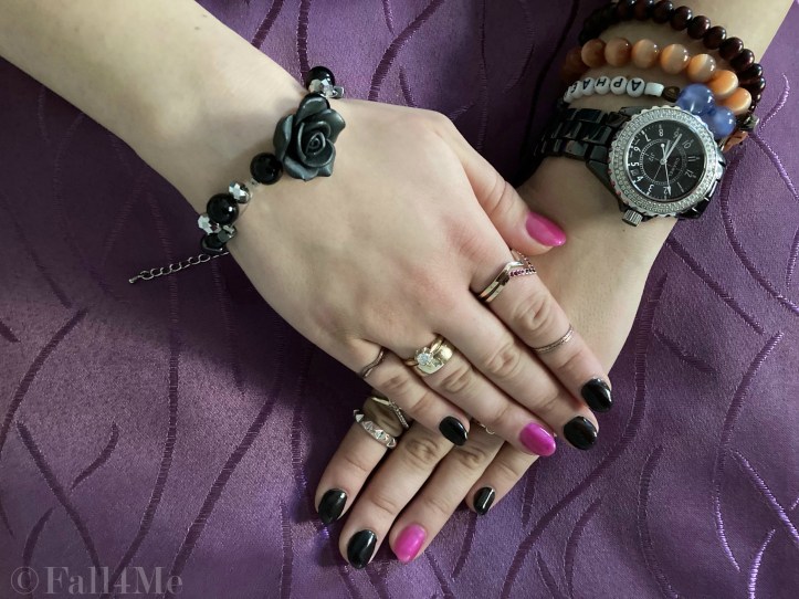 Black nails with pink having a slight blue shimmer and rocky accessories.