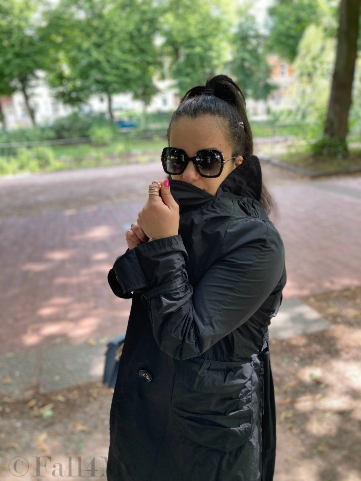 A black trench coat worn with skinny jeans and a leopard printed blouse.