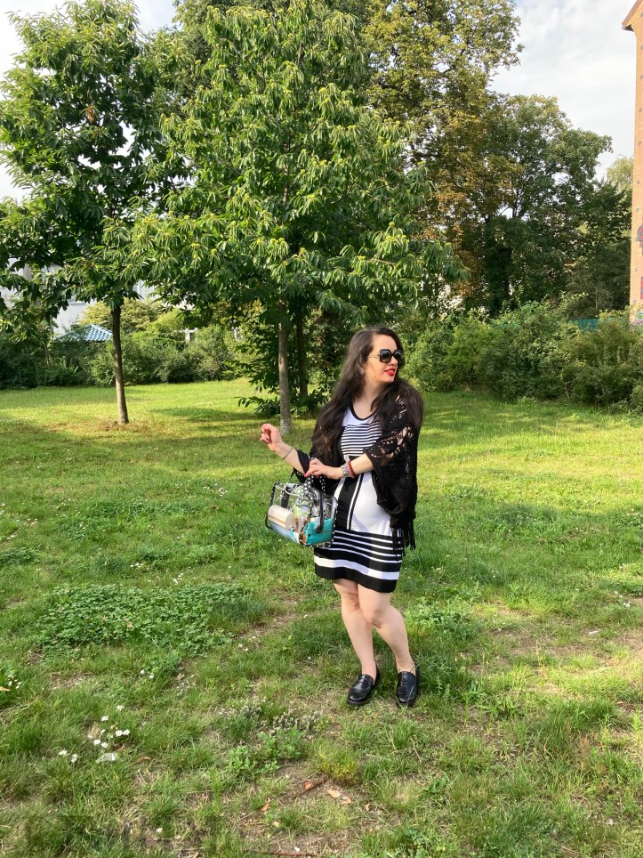 A black and white dress combined with red lips and a transparent handbag.