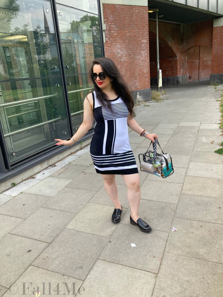 A black and white dress combined with red lips and a transparent handbag.