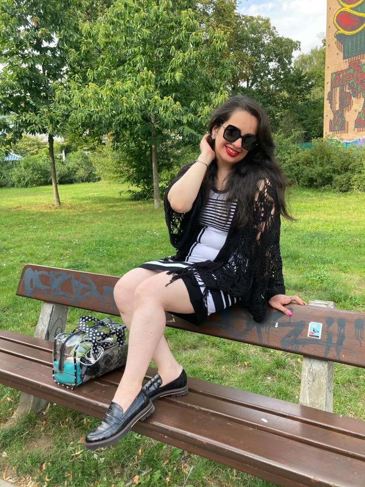 A black and white dress combined with red lips and a transparent handbag.