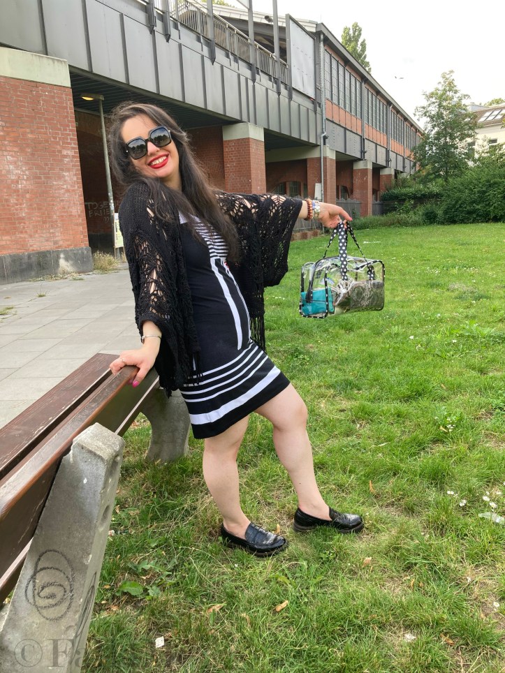 A black and white dress combined with red lips and a transparent handbag.