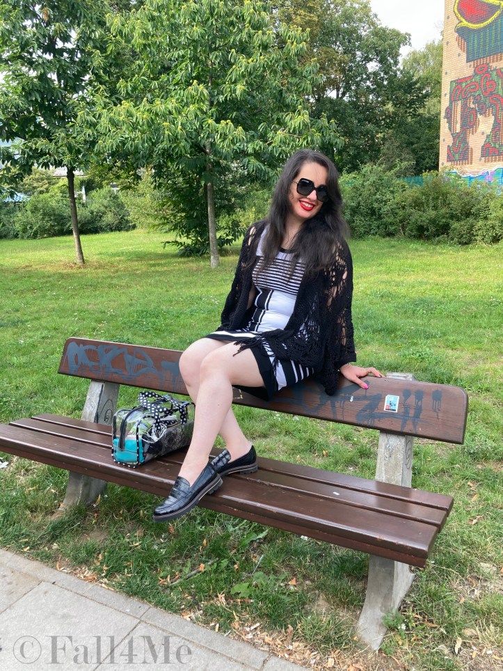 A black and white dress combined with red lips and a transparent handbag.
