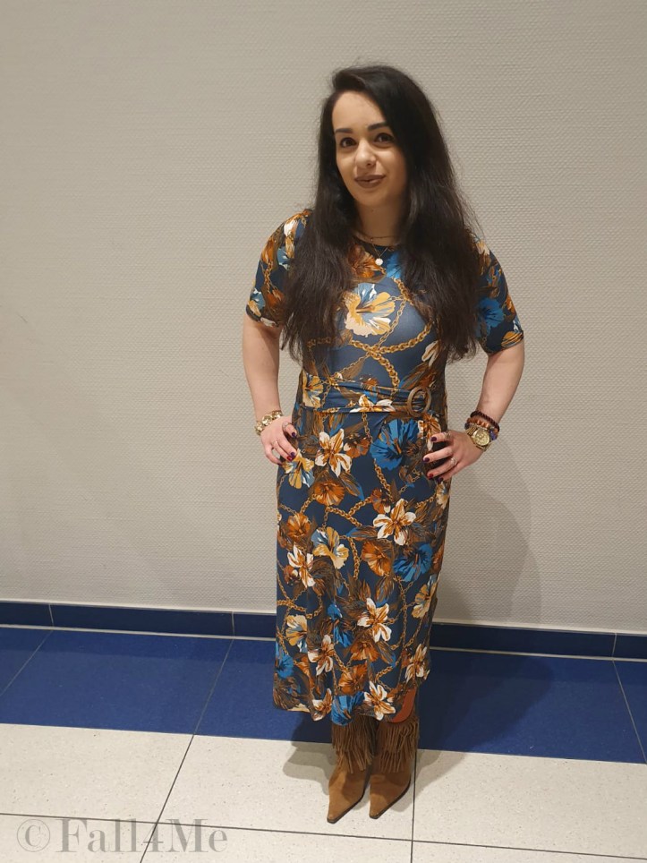 A turquoise dress with flowers in shades of cognac and golden accessories.