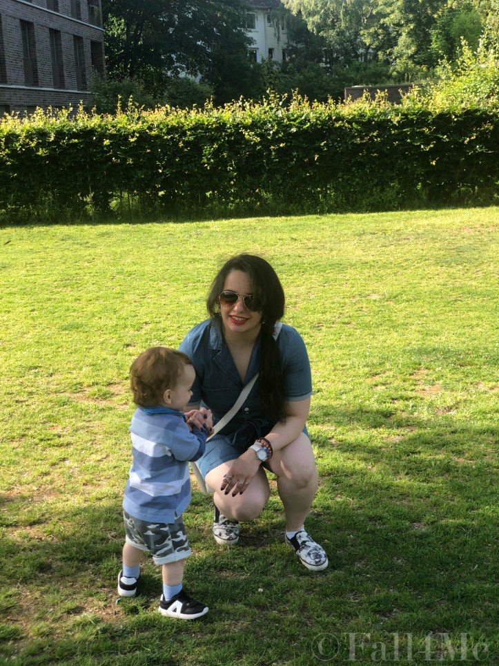 A denim jumpsuit combined with white leather accessories, silver jewellery and a red lipstick.