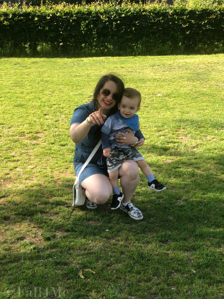 A denim jumpsuit combined with white leather accessories, silver jewellery and a red lipstick.
