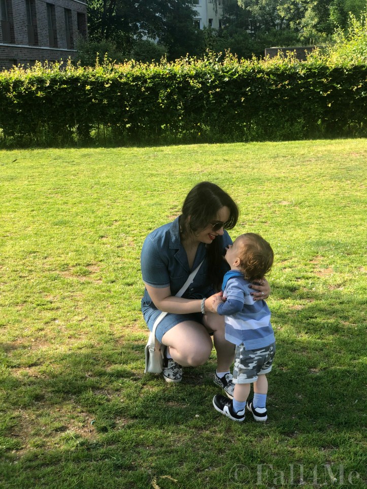 A denim jumpsuit combined with white leather accessories, silver jewellery and a red lipstick.