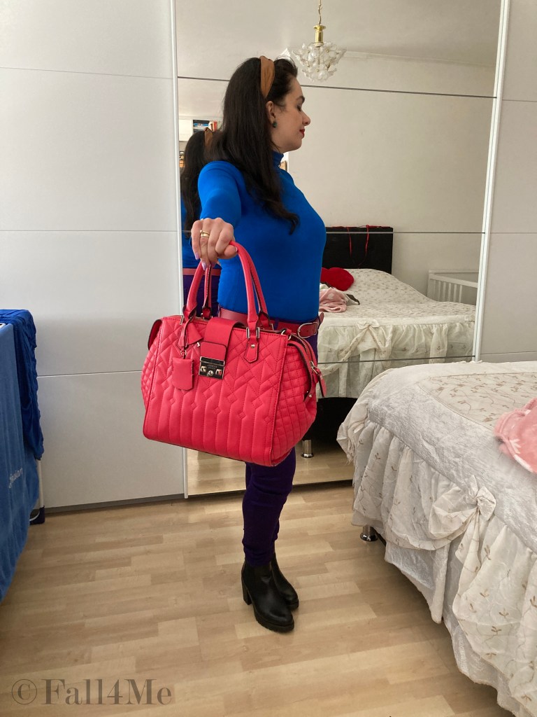 Color-blocking style with a trendy pink bag and colorful stud earrings.