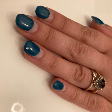 Trendy nails in a deep petrol with a little glitter stone.