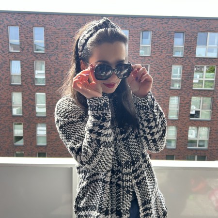 Oversized checked bouclé coat with jeans and red pumps.