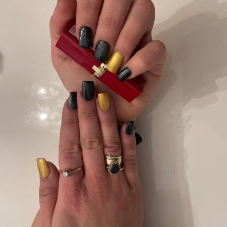 Nails in Black and Gold posing with red lipstick.